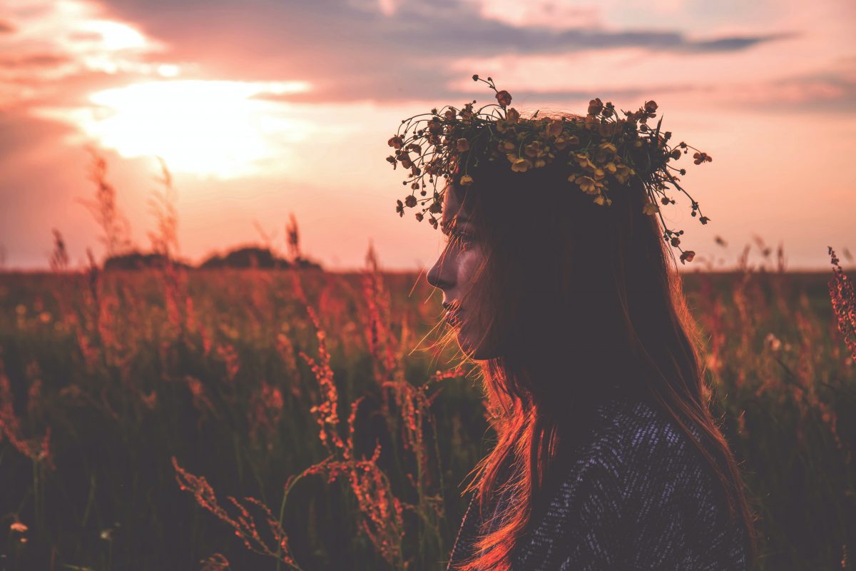 Jeune femme dans un champ portant une couronne de fleurs